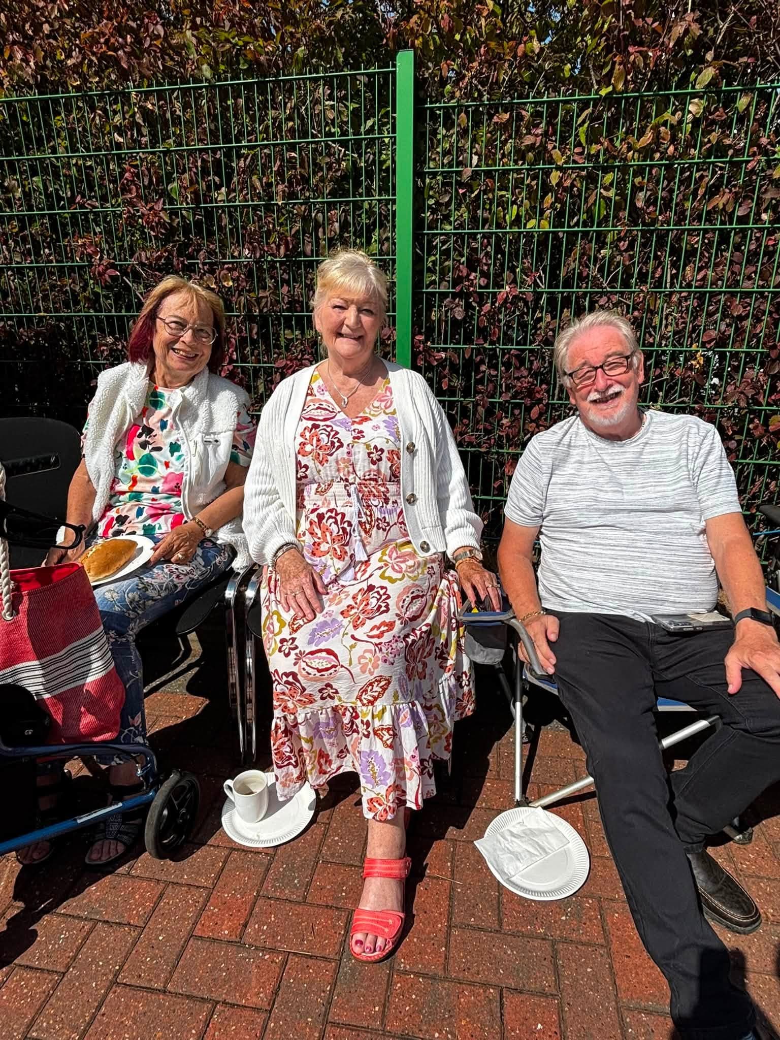 Three guests smiling together during the community celebration