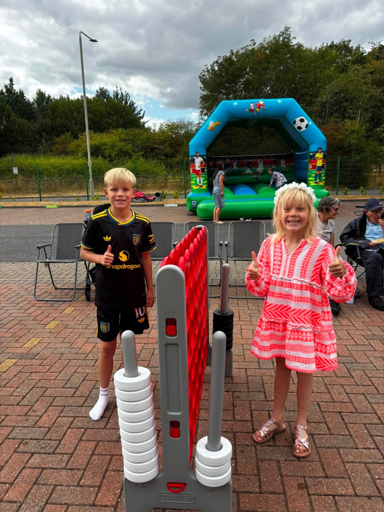 Children playing an outdoor game beside the inflatable play area