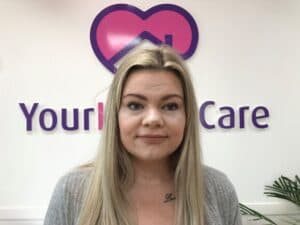 Ebony in front of the Your Home Care logo