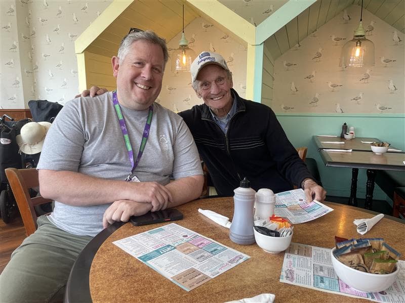 Two men smiling at the seaside