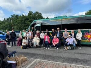 Clients and staff in front of the travel coach, ready to set off for their day trip to Skegness.