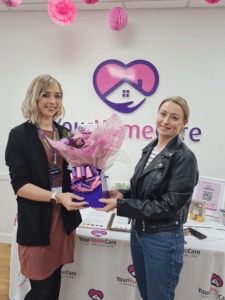 Harriett presenting Stacie with a bouquet of flowers